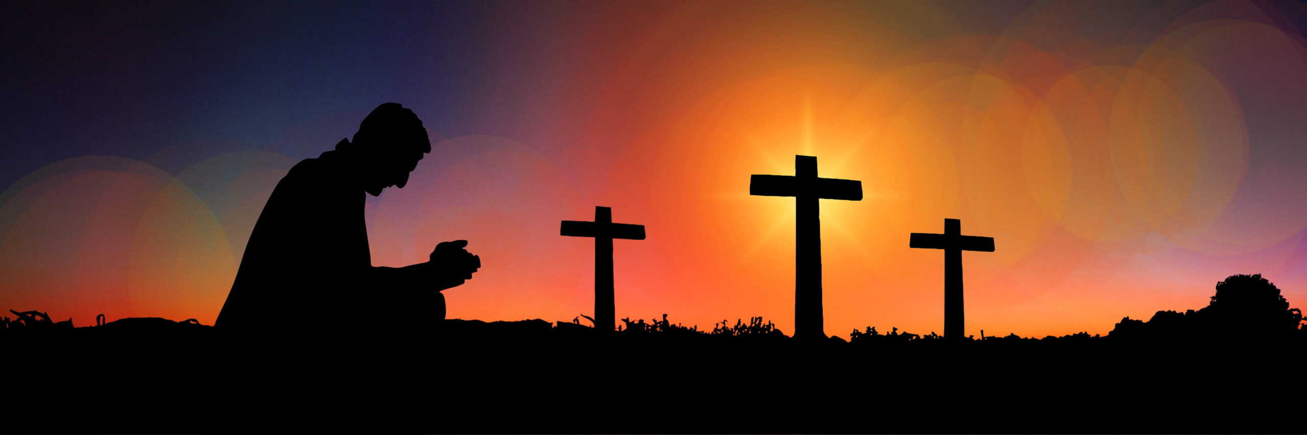 Praying at sunset with crosses in the background