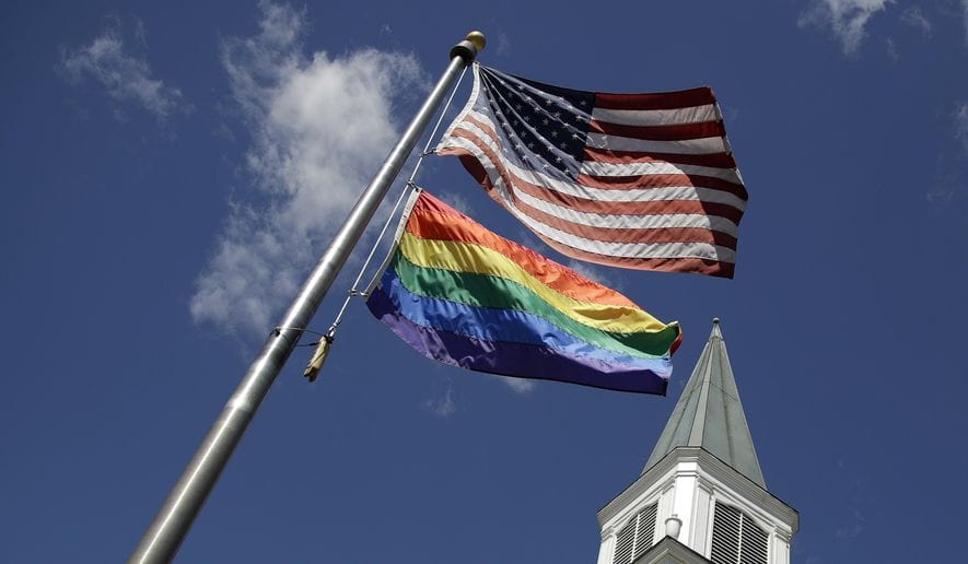 Church Steeple and flag pole with both the American flag and the Pride flag.