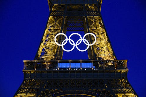 The Eiffel Tower with the Olympic rings at night.