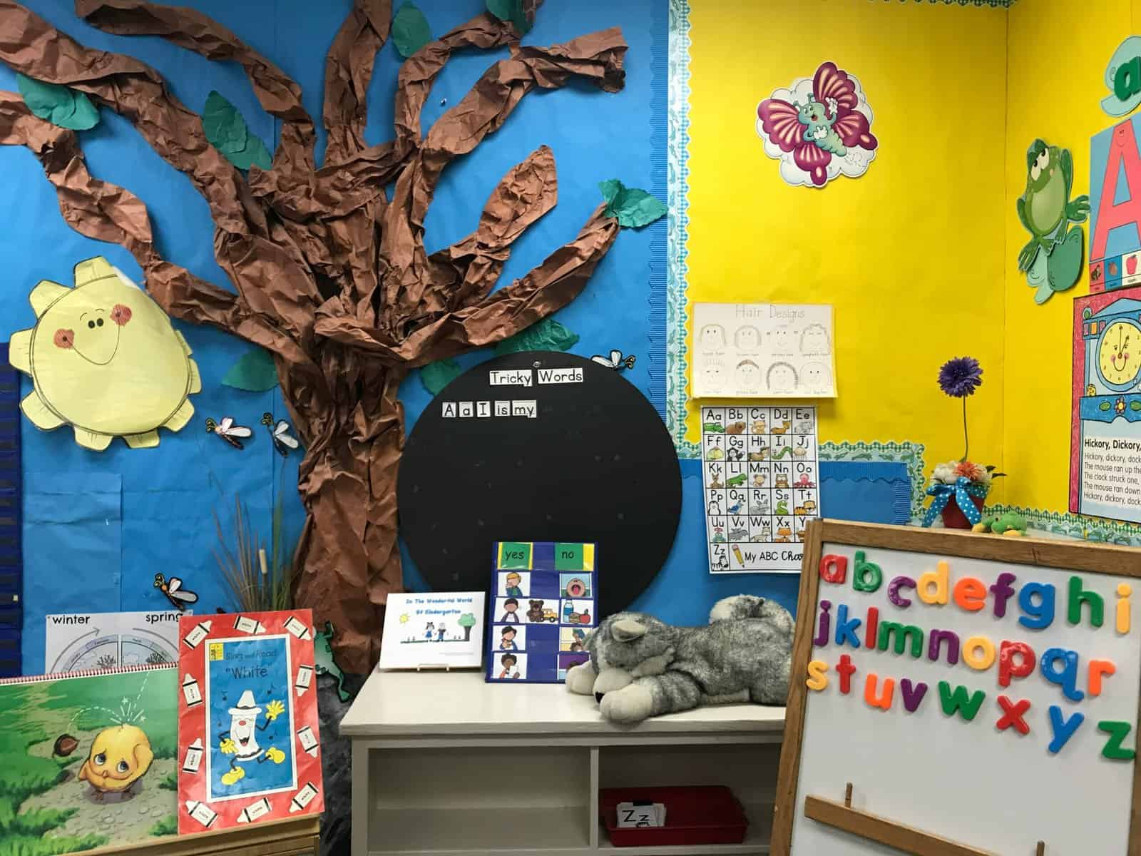 A corner of a child's classroom decorated with colorful walls and charts.