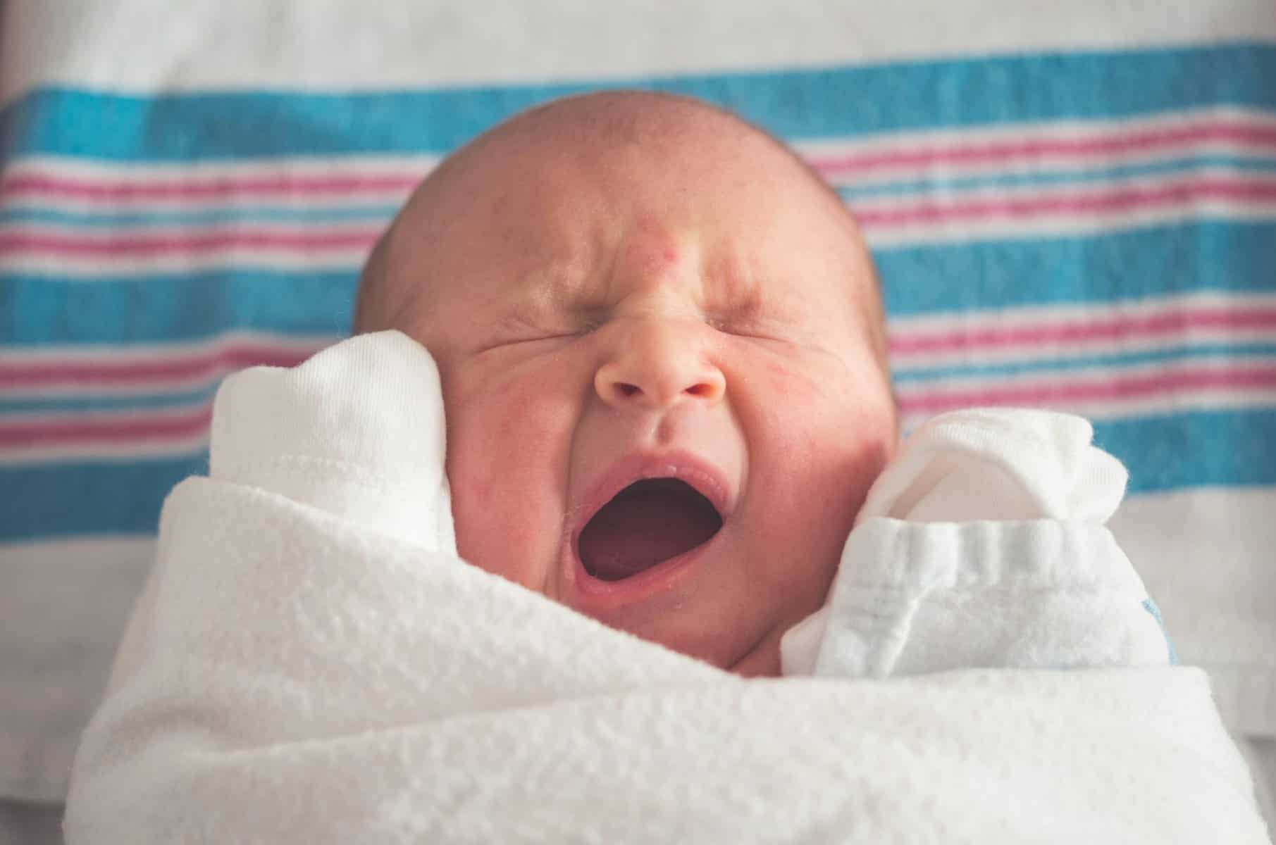 A newborn baby yawns.