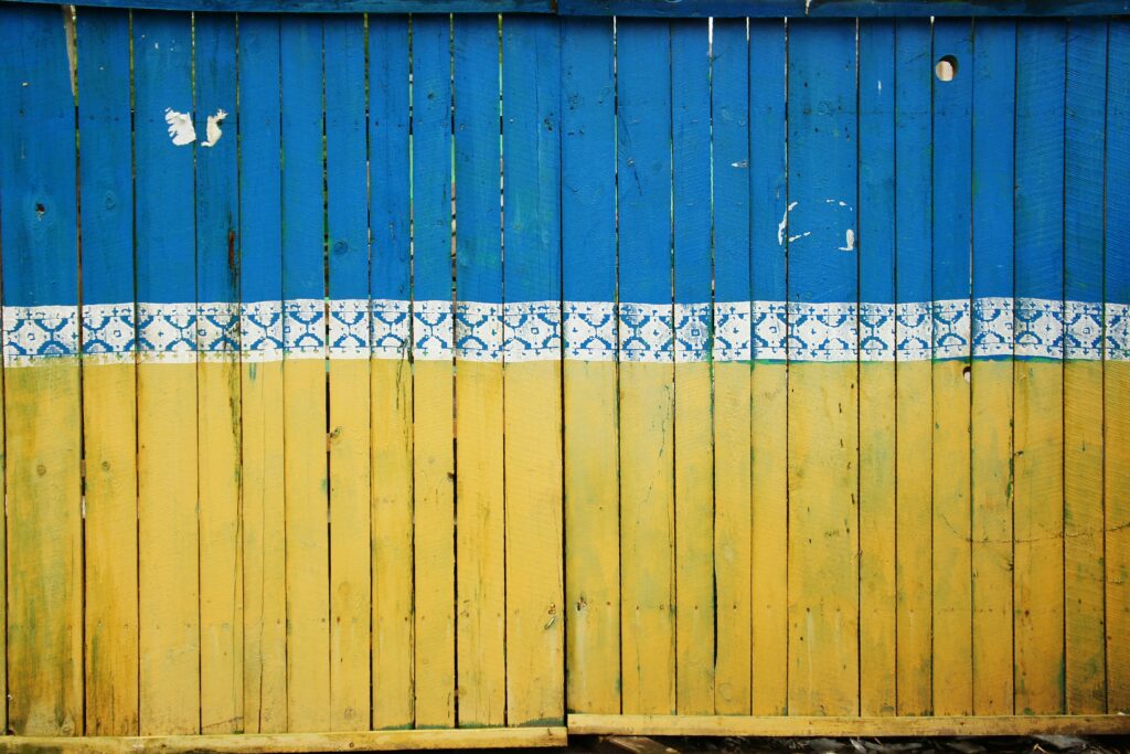 A fence painted in blue and yellow like the flag of Ukraine.