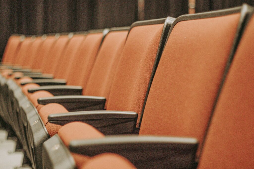 A row of rust colored auditorium seats.