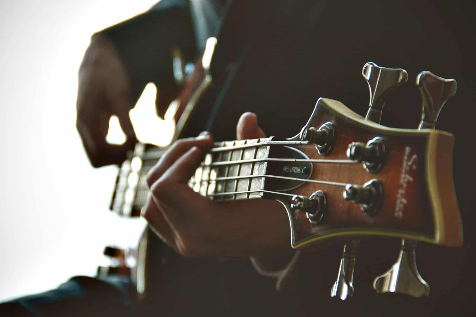 Close up focus of the top of a guitar as it's being played.