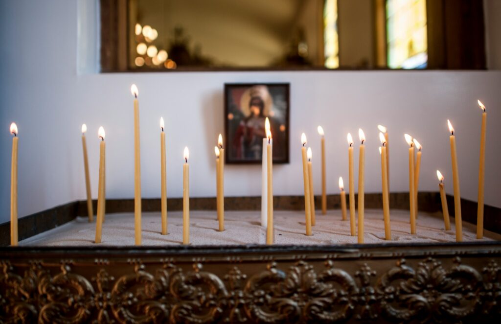 Thin lit candles on a wooden table.