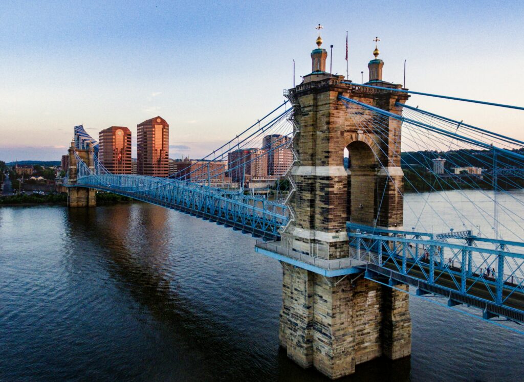 A large stone bridge over a river in Ohio with a city in the background.