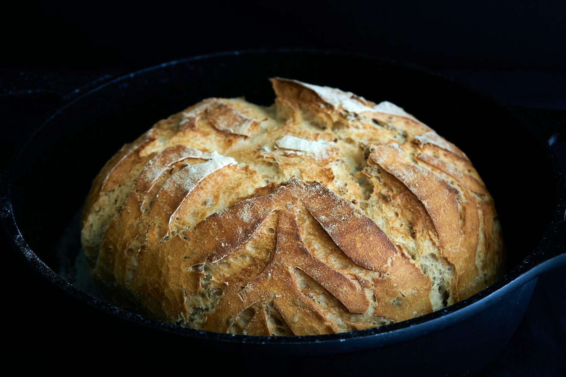 A loaf of fresh baked bread with decorative scoring.