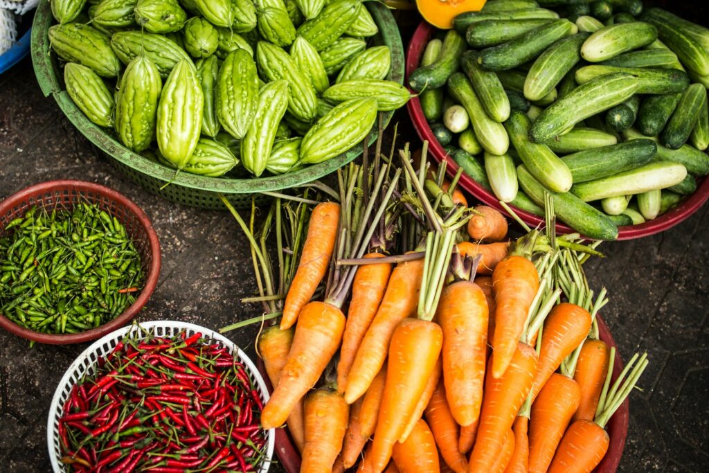 Fresh vegetables shown in piles or bowls.