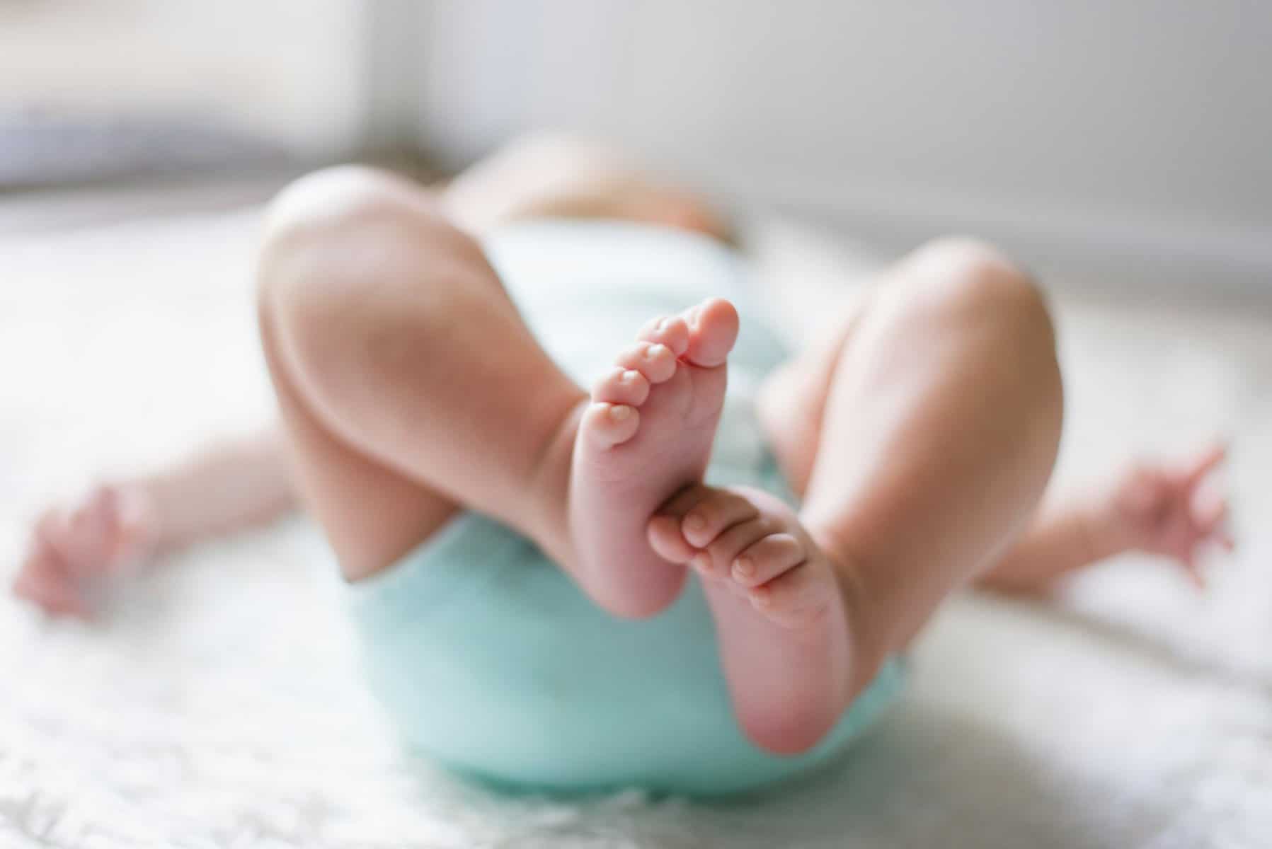 A baby's feet are in focus with the rest of the body out of focus.