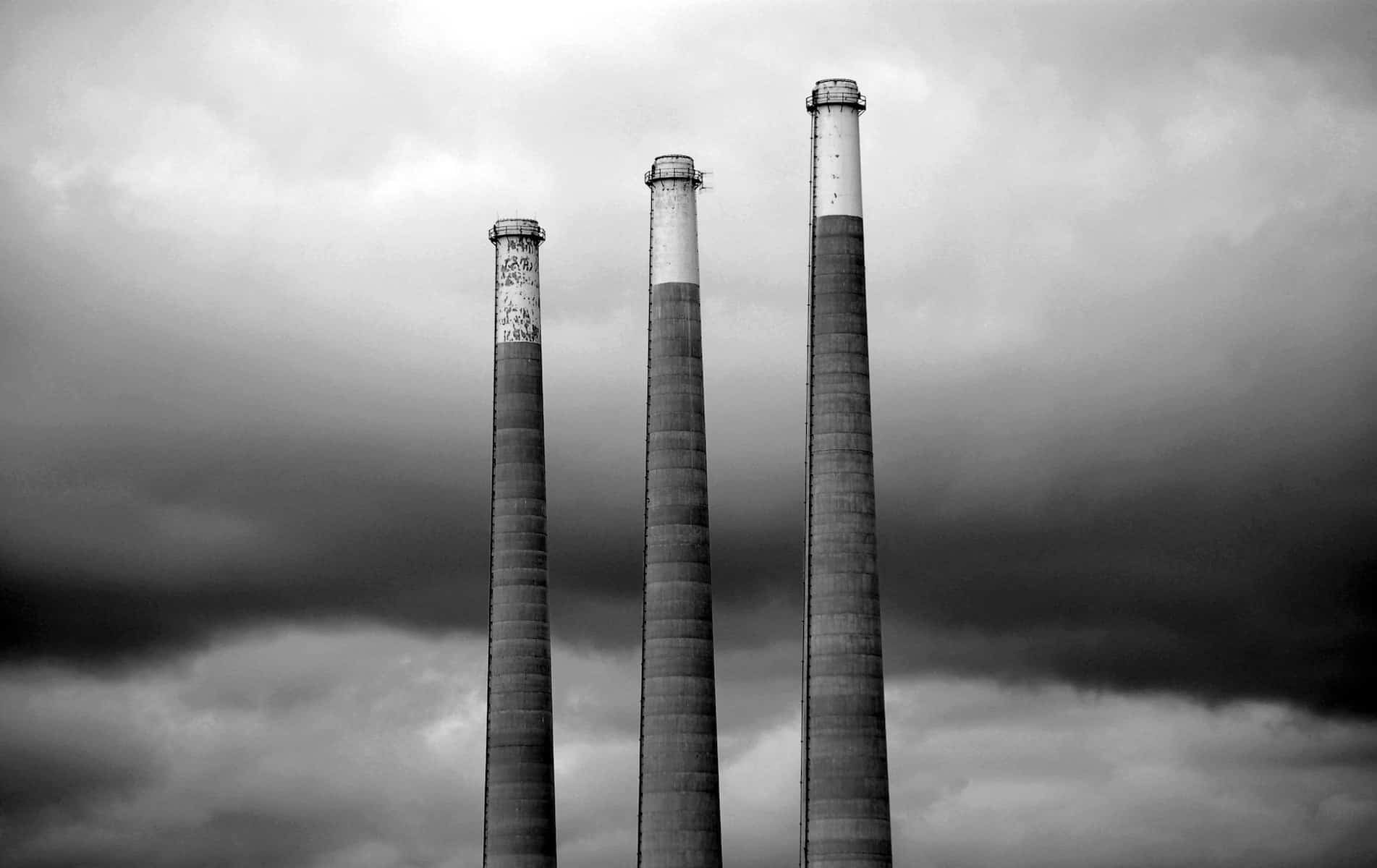 Three smokestacks in grey scale.