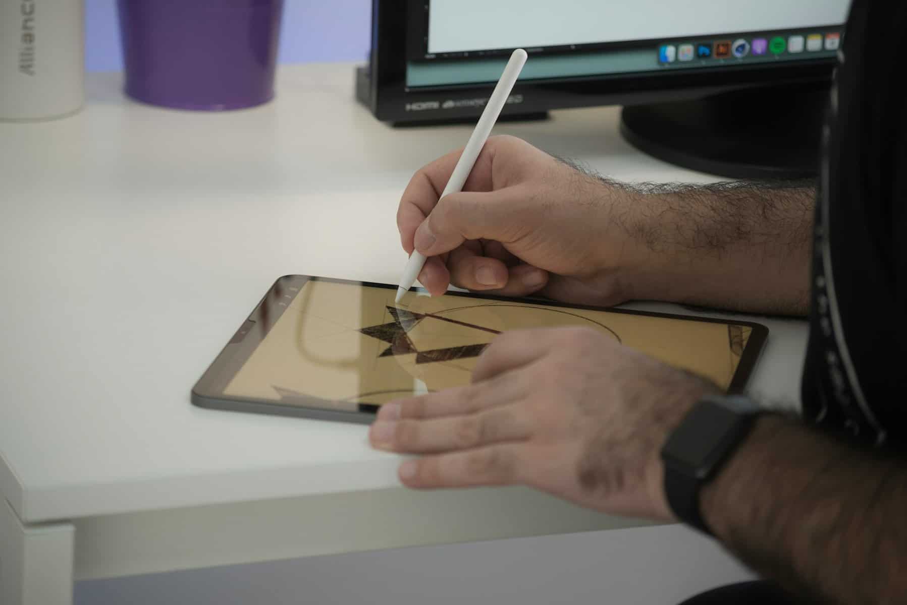 A digital tablet with a man drawing on it.