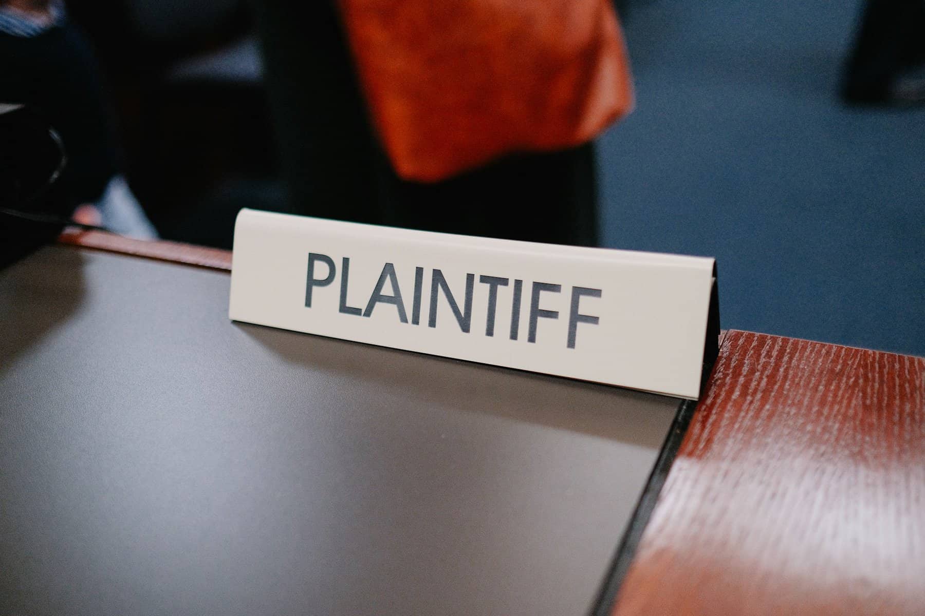 A sign on a desk says "plaintiff."