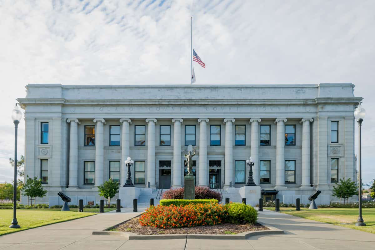 A courthouse with the U.S. flag half staff.