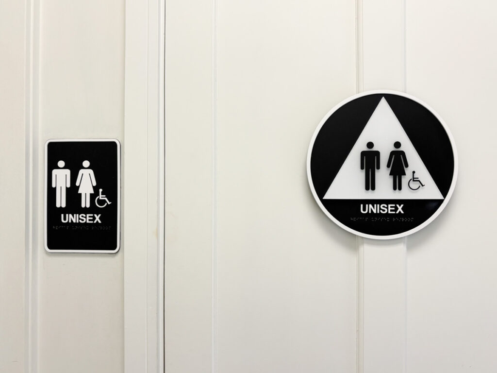 Unisex bathroom sign on a white door.