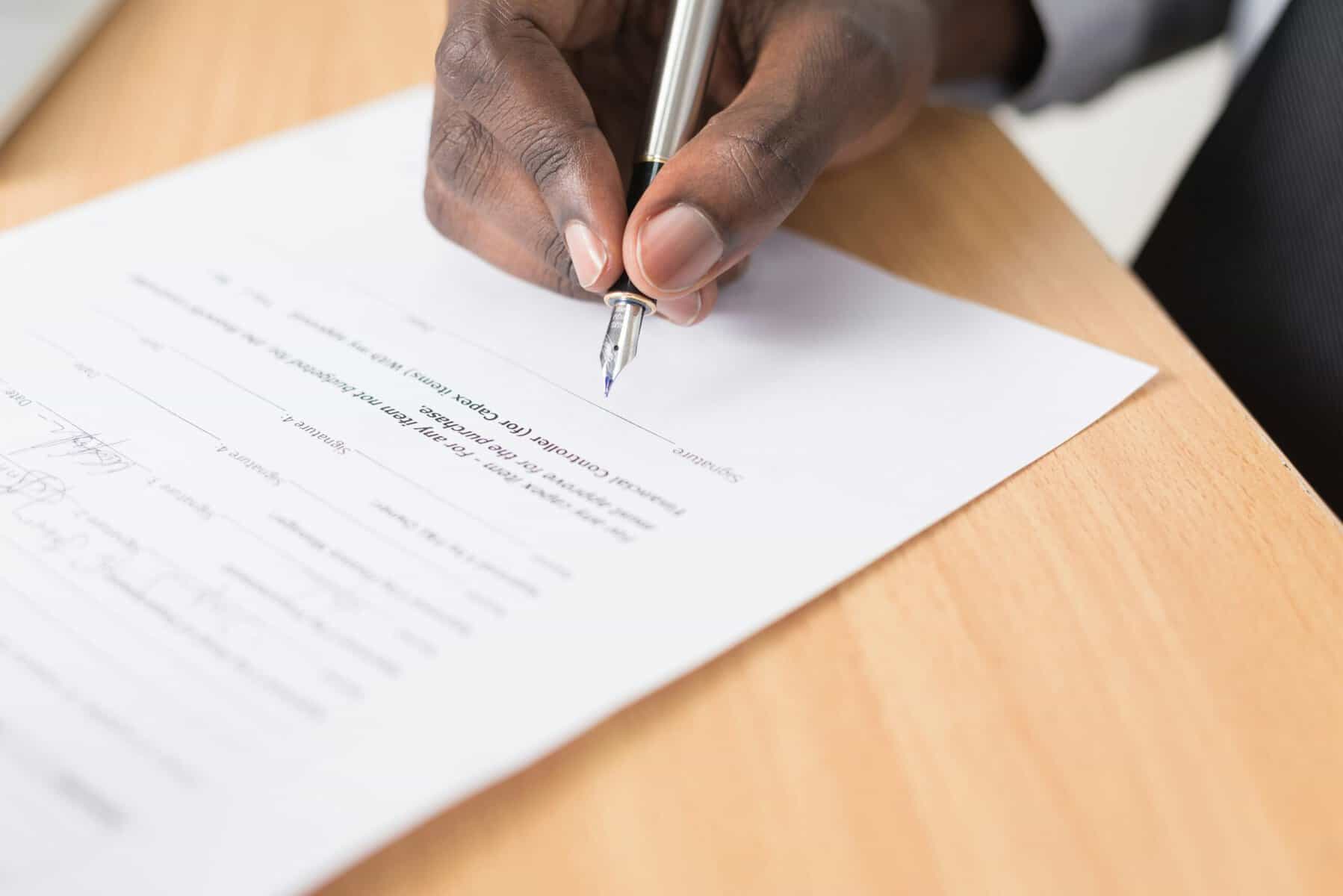 A person signing a piece of paper.