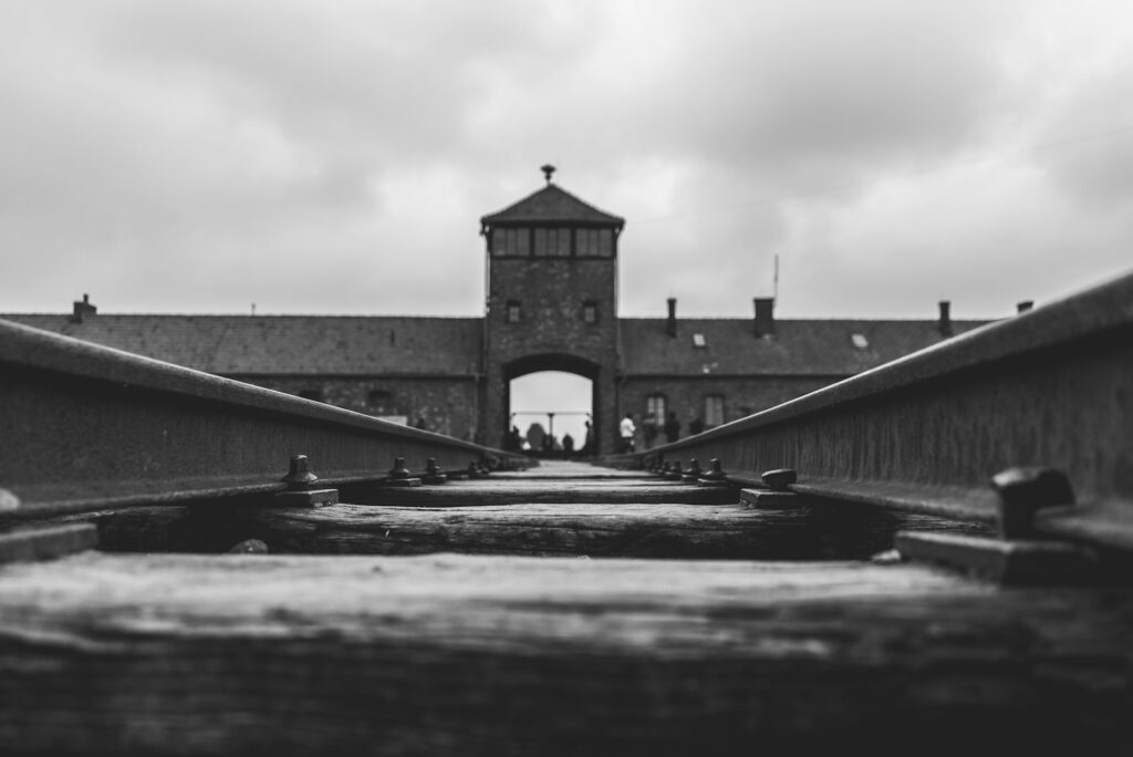 Auschwitz seen at a forced perspective from between train tracks.