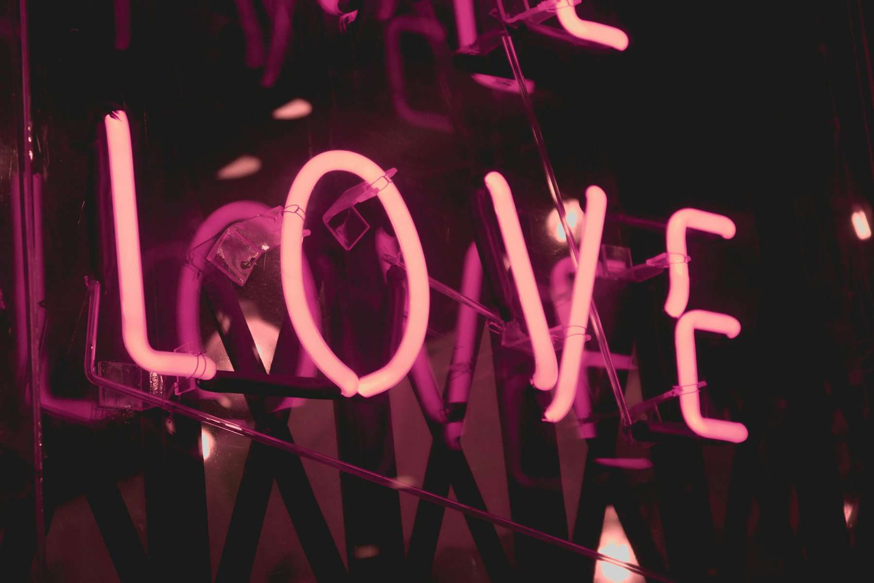 A pink neon sign says LOVE