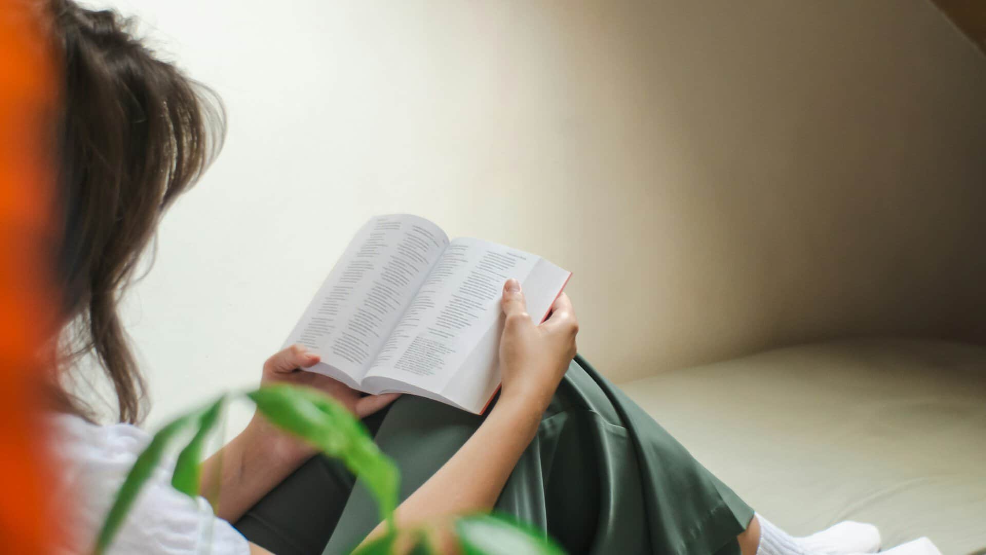 Woman sitting on the floor reading a Bible.