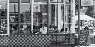 A young boy sits on a wall outside Delores Park Cafe in San Francisco.