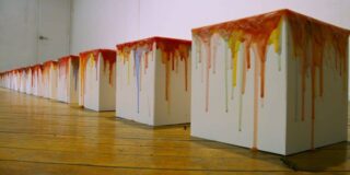 The Knowledge Series by Rondall Reynoso consists of a row of white wooden boxes with painted tops in shades of red that drip over the sides. Knowledge Series, 2004