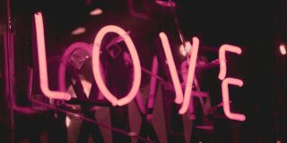 A pink neon sign says LOVE