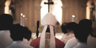 A man with a Bishops hat walks away from the camera.