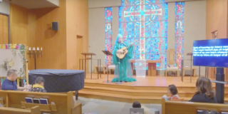 The colorful altar decorated in blues and with a stained glass backdrop is shown.