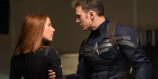 Captain America holding Black Widow by the arm as they look at each other intensely.