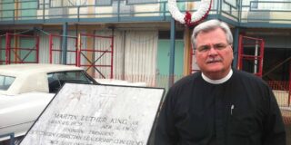Pastor in his collar standing at the plaque commemorating the location where Martin Luther King Jr. was assassinated.