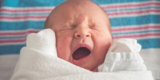 A newborn baby yawns.