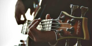 Close up focus of the top of a guitar as it's being played.