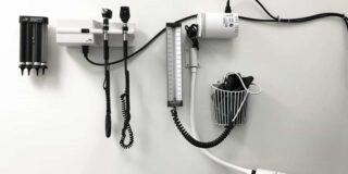 Typical medical tools and devices mounted on an exam room wall.