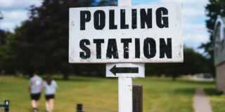 A white sign with black lettering that says "Polling Place" with a directional arrow.