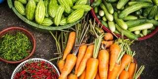 Fresh vegetables shown in piles or bowls.