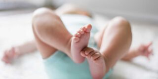 A baby's feet are in focus with the rest of the body out of focus.