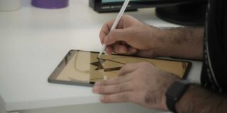 A digital tablet with a man drawing on it.